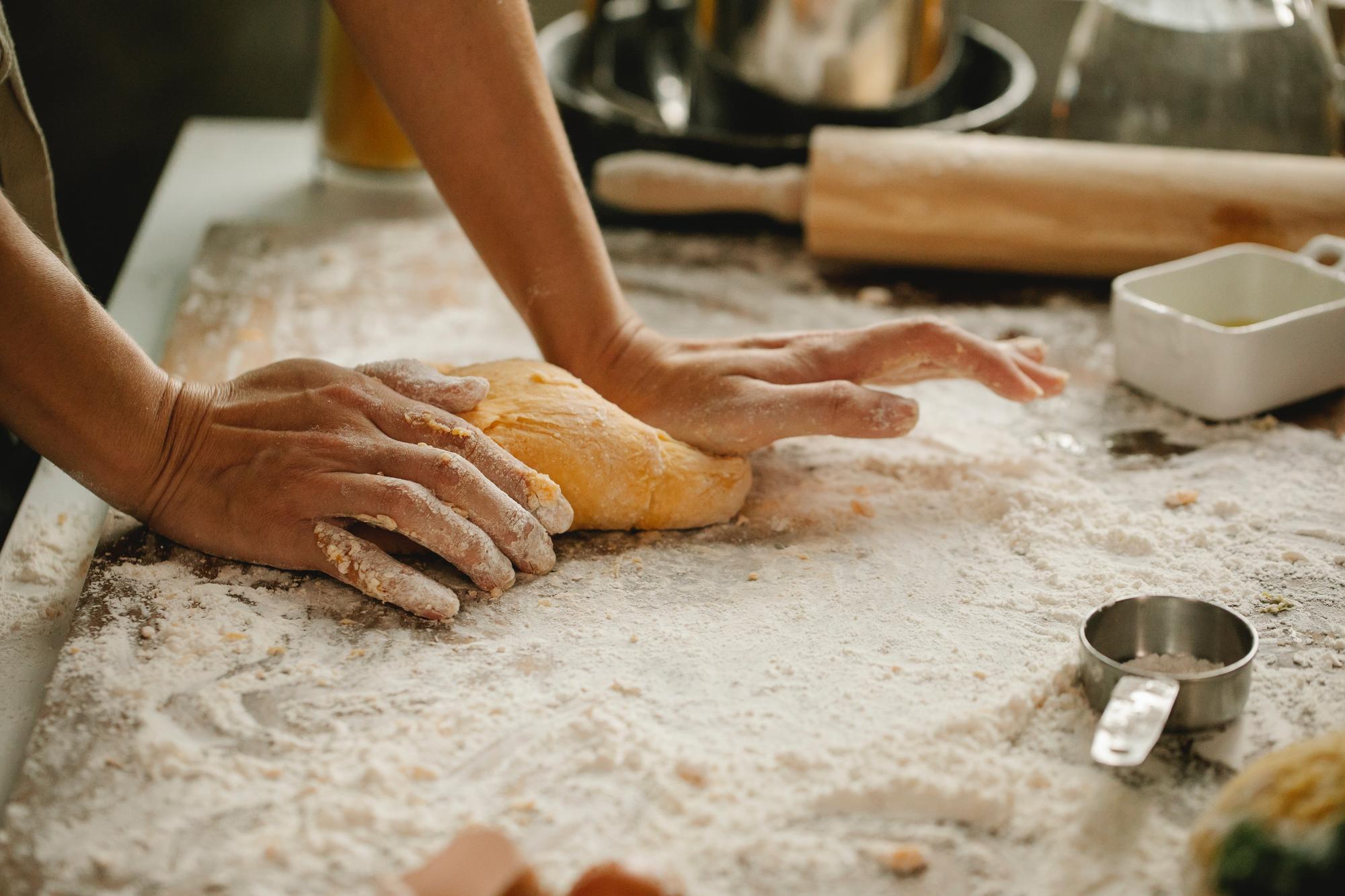 Close-up of hands shaping dough in workshop